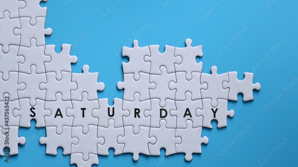 SATURDAY word written on white jigsaw puzzle