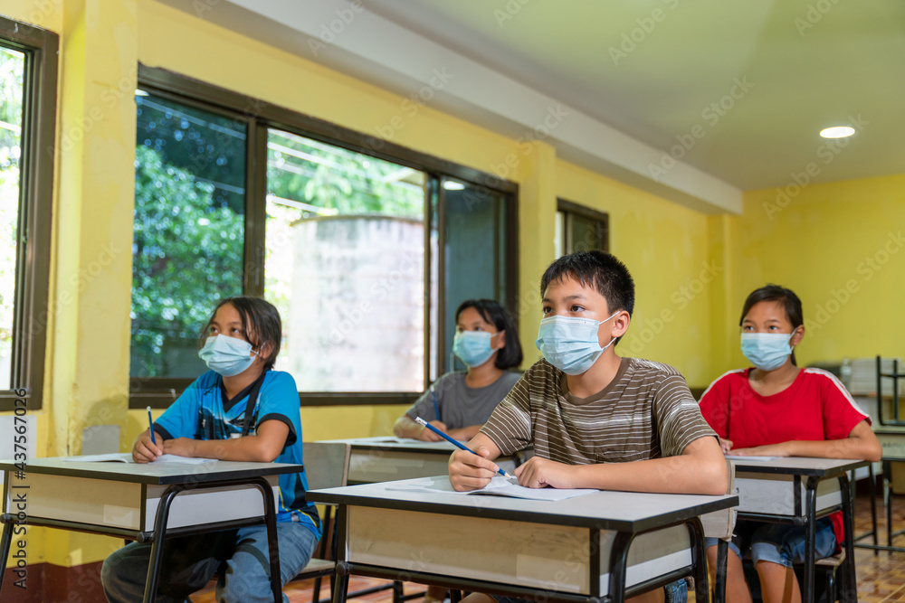 Group of asian children in classroom with face mask back at school after covid-19 quarantine and lockdown.