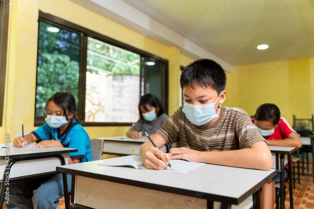 Group of asian children studying in classroom with face mask back at school after covid-19 quarantine and lockdown. Group of asian children studying in classroom with face mask back at school after covid-19 quarantine and lockdown.