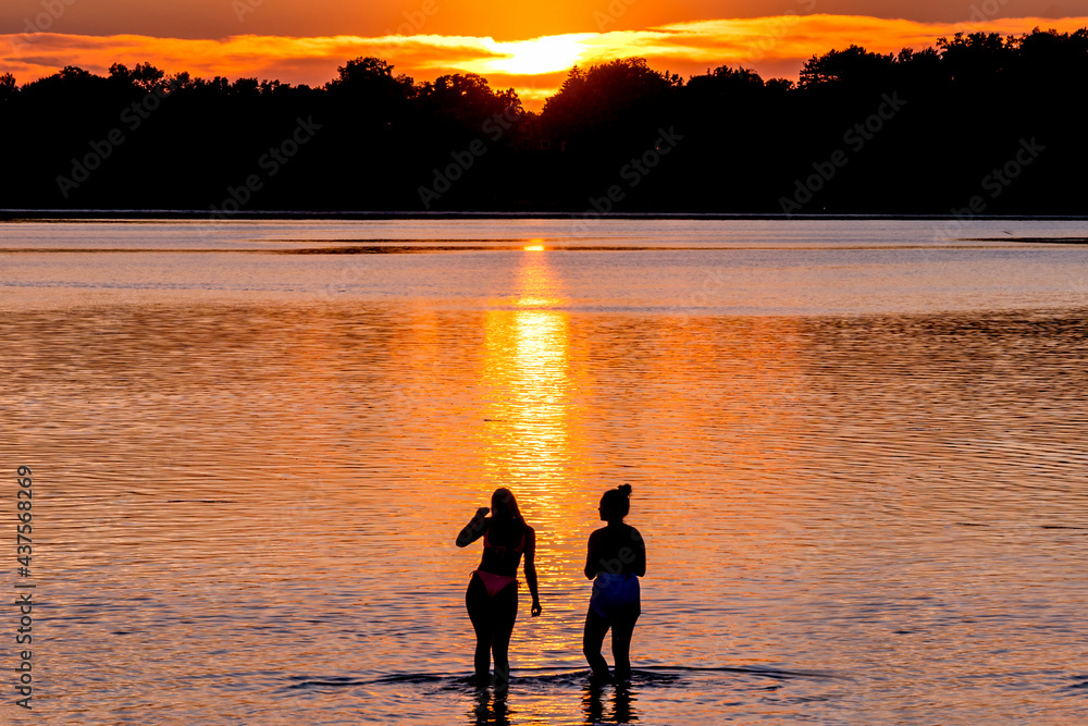 Fototapeta premium People are having fun in a lake under sunset 