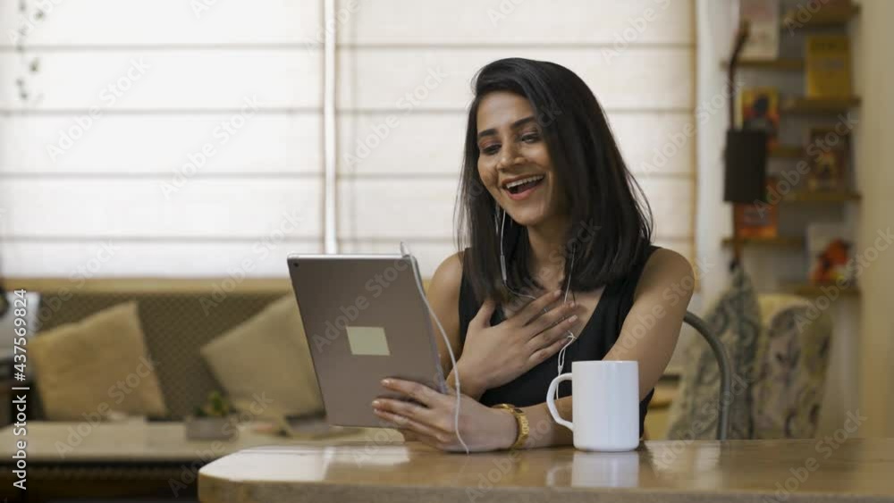 Pretty happy smiling Asian young woman making video call at home using tablet waving hand to camera while video chatting .Close up portrait of attractive young Asian female making video call indoor. Pretty happy smiling Asian young woman making video call at home using tablet waving hand to camera while video chatting .Close up portrait of attractive young Asian female making video call indoor.