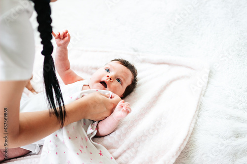 mom wipes baby's burp from her lips after feeding photo