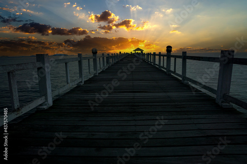 Wooden bridge in the sea sunrise landscape on background © K.Pornsatid