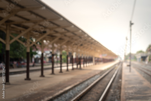 Blurred background of traditional rural train station and railway track without people. Transportation system background photo.