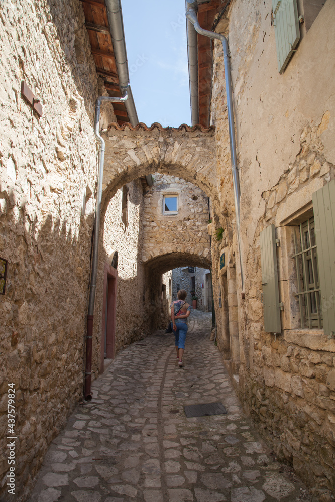 Femme touriste montant  une ruelle déserte du vieux village de Mirmande (Drôme)