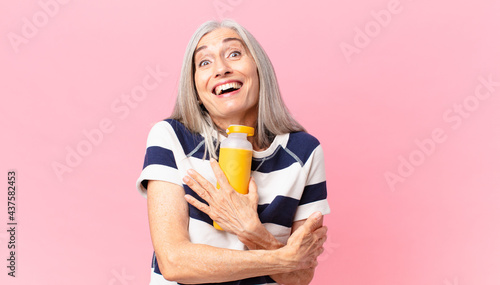 middle age white hair woman holding a coffee thermos photo