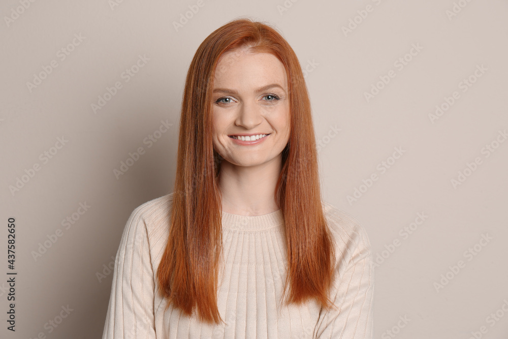 Candid portrait of happy young woman with charming smile and gorgeous red hair on beige background Candid portrait of happy young woman with charming smile and gorgeous red hair on beige background