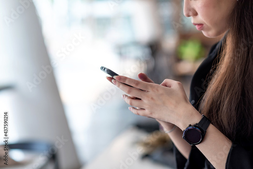 Businesswoman sitting and relaxing using a smartphone at the office. Free Download Businesswoman sitting and relaxing using a smartphone at the office. - GFXLoad