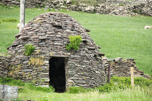 Early medieval stone-built round house clochain (beehive hut) on Dingle Peninsula, Kerry, Ireland. A Clochain is a dry-stone hut with a corbelled roof, commonly associated with the south-western Irish photo