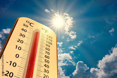low angle view Thermometer on blue sky with sun shining in summer show higher Weather, concept global warming