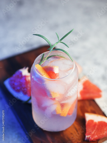 Refreshing summer cocktail with grapefruit, rosemary. Stylish glass , concrete white table