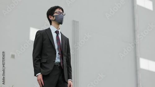 コロナ禍にビジネスパーソンがやや不満そうにマスクを外す1