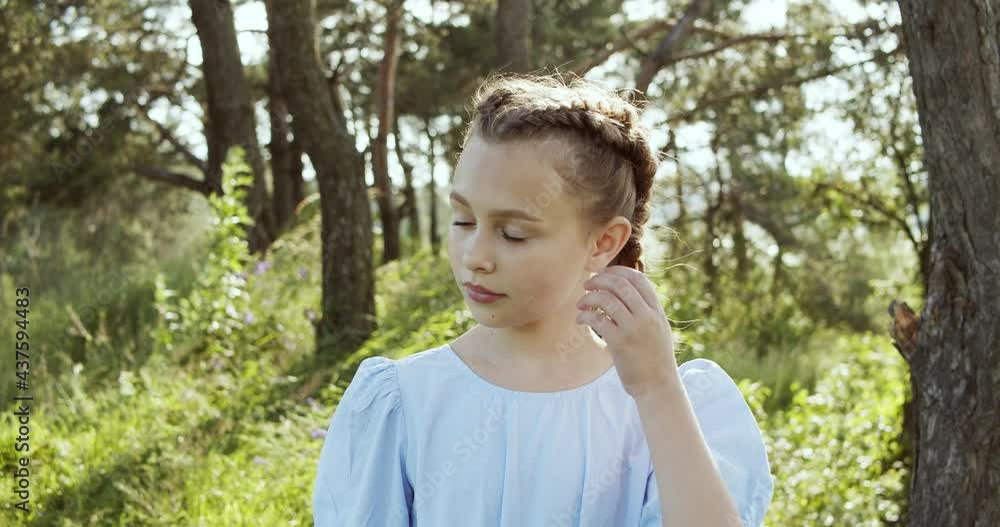 Attractive European blonde teen girl with natural make-up looks into the camera in nature on a sunny day. Attractive European blonde teen girl with natural make-up looks into the camera in nature on a sunny day.