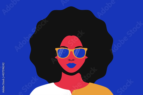 Portrait of a woman with a lush hairstyle in sunglasses
