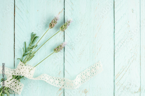 lavender flowers on a green wooden background decorated with ribbon