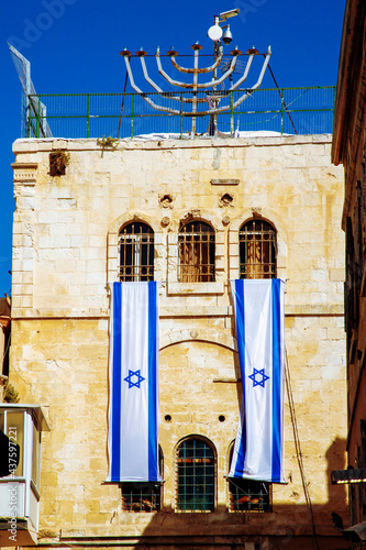 The Hanukkah menorah or hanukkiah and 2 israel flags on a building in the old city of Jerusalem, israel photo