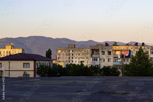 Multi-storey residential Soviet panel houses against the backdrop of mountains.
