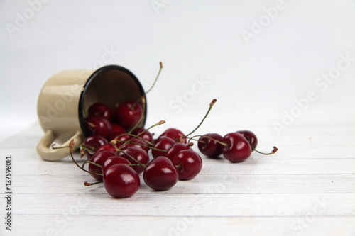 a metall mug of black cherry lying on white background
