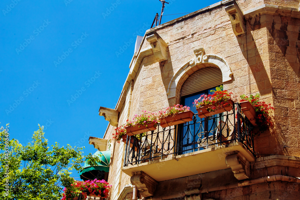balcony decorated with pots with bright flowers on a sunny day, balcony floristic decoration
