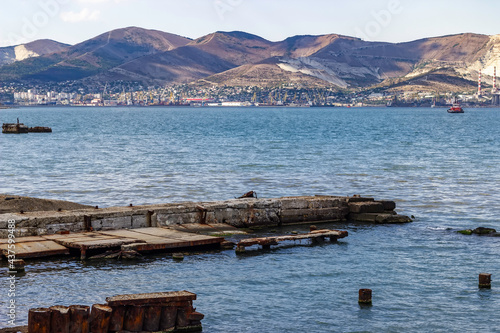 An ancient ruined boat dock. View of the city and mountains in the background.