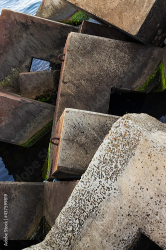 Square stones of breakwaters and the surface of water sea.