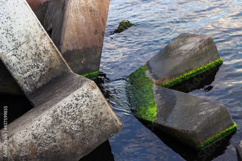 Square stones of breakwaters and the surface of water sea.