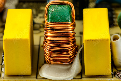 An inductor, toroidal coil on a ring with visible copper scroll, wound on a magnetic coil.