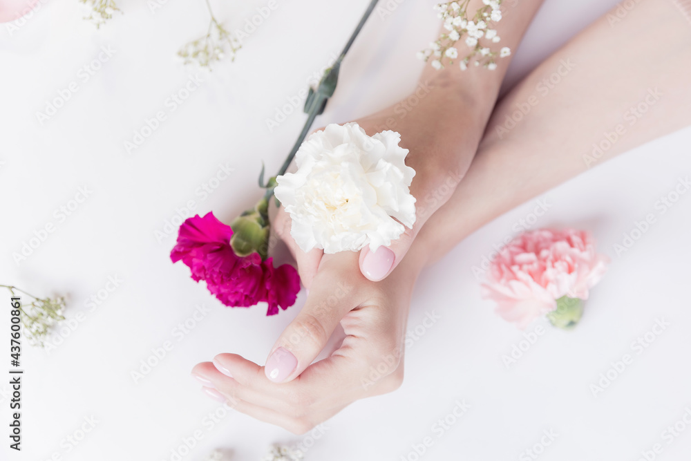 Concept beauty skin care. Beautiful stylish trendy female pink manicure with flower on background, top view