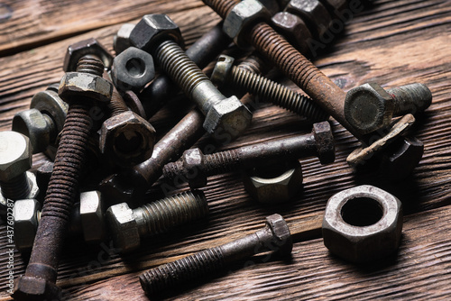 Old rusty bolts and nuts on the carpenter workbench background.