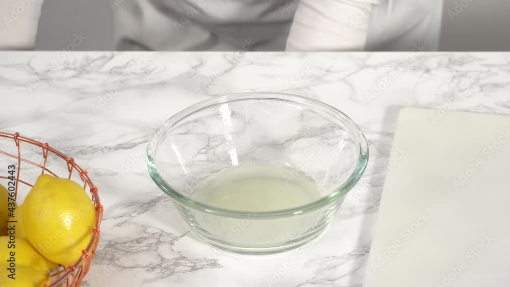 Step by step. Squeezing fresh lemon juice into a small glass mixing bowl. Step by step. Squeezing fresh lemon juice into a small glass mixing bowl.