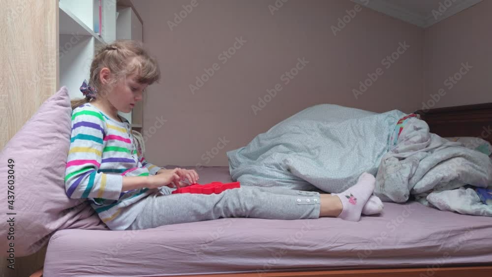 Girl with fidget toy on the bed home interior Girl with fidget toy on the bed home interior