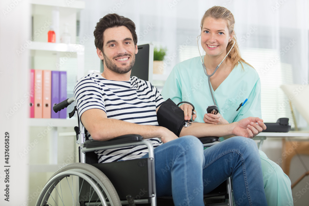 nurse taking blood pressure of disabled man nurse taking blood pressure of disabled man