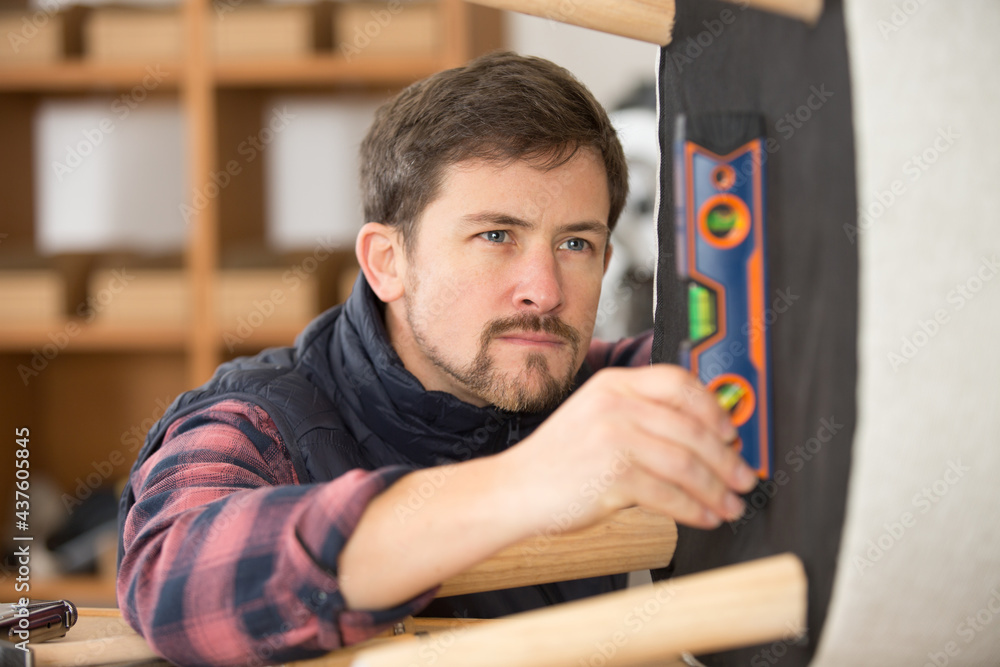 male technician uses a sprit level male technician uses a sprit level