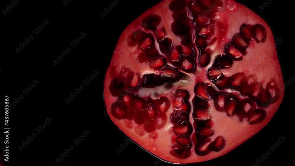 Pomegranate rotating in a pomegranate red juice. Slice of grenade fruit floating in a juice. Summer tropical fruits. Pomegranate rotating in a pomegranate red juice. Slice of grenade fruit floating in a juice. Summer tropical fruits.