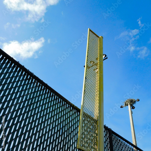 Afternoon sun shining on outfield fence and foul pole.
