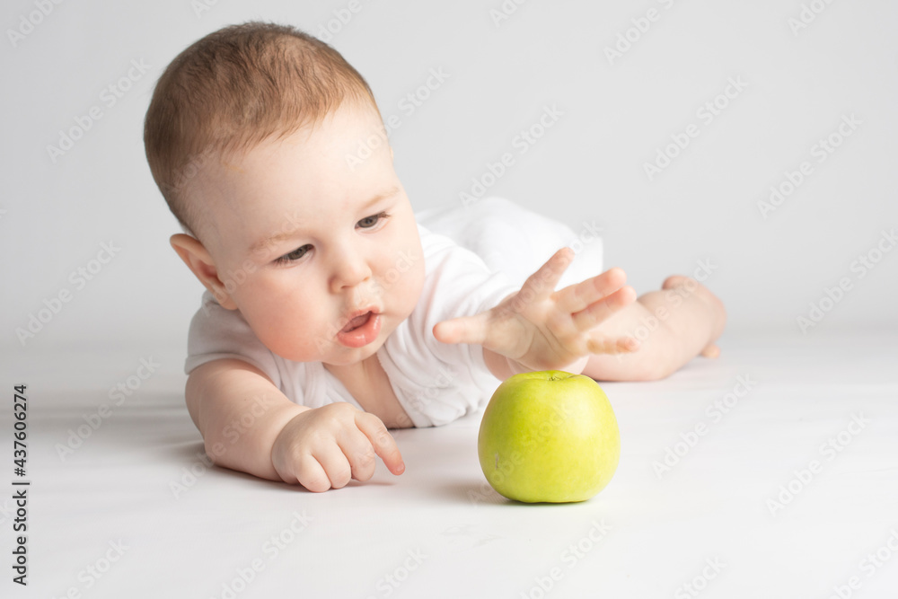 child reaches for a green apple child reaches for a green apple