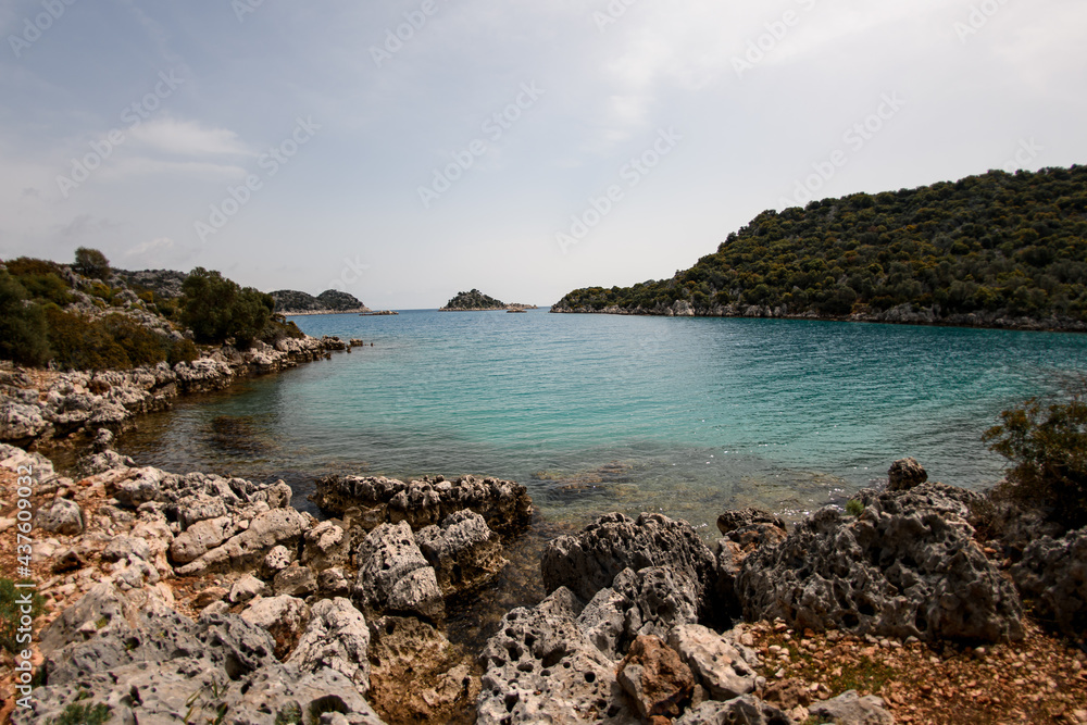View of turquoise water of the sea and rocky coast and blue sky