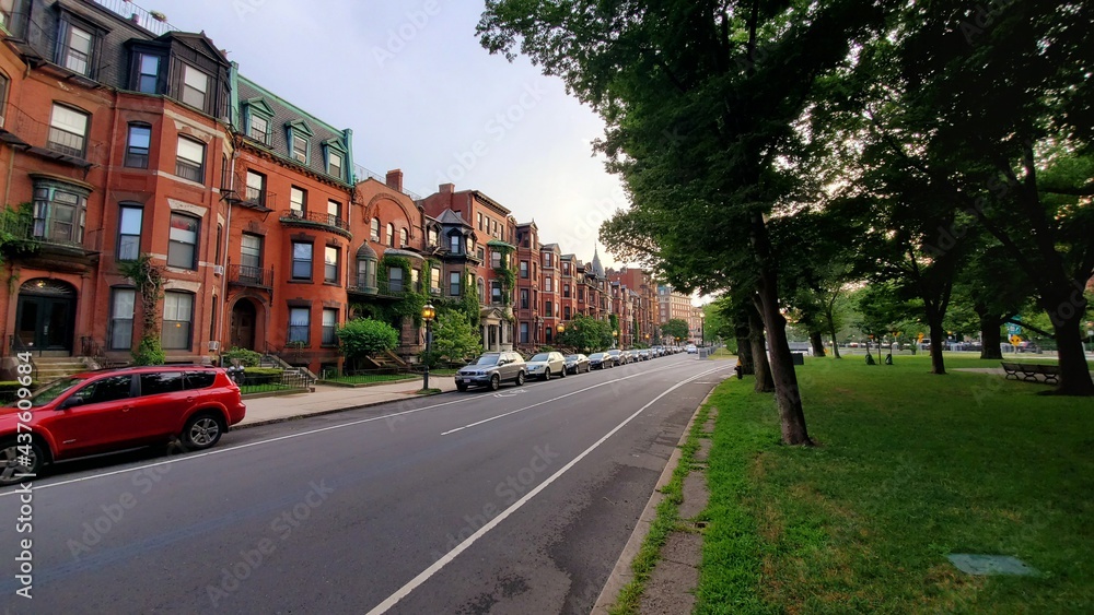 green street in an old town with red buildings, trees and cars (Commonewalth Avenue)