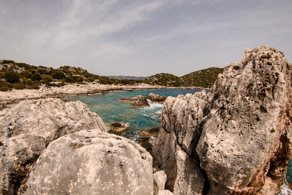 beautiful view of the sea, mountains and sky from the stoned shore.