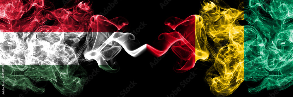 Obraz premium Hungary, Hungarian vs Guinea smoky flags side by side.