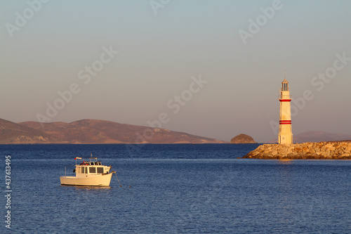 Seascape at sunshine. Lighthouse and sailings on the coast. Seaside town of Turgutreis and spectacular sunshine. 