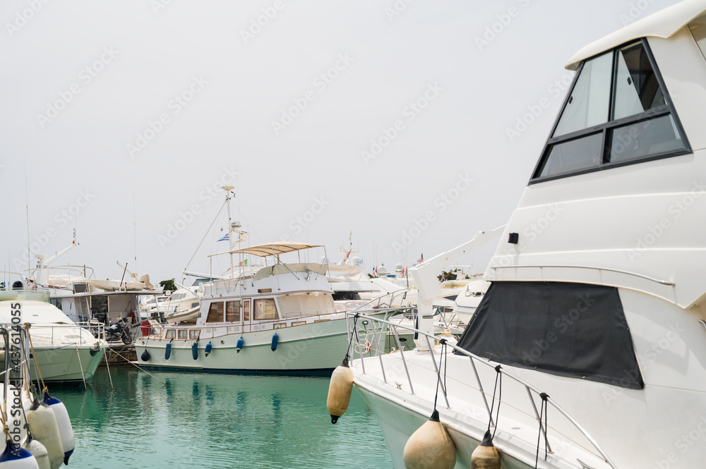 Fototapeta premium Boats parking in harbor. White motorboat at the pier. Sea yacht club. Aegean sea. Athens, Greece. White cloudy sky.