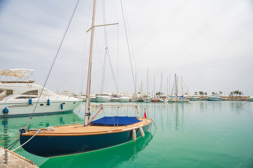 Yacht parking in harbor. White sailing yachts at the pier. Sea yacht club. Aegean sea. Athens, Greece. Blue sky.