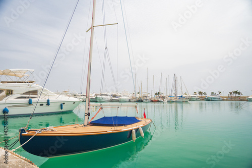 Yacht parking in harbor. White sailing yachts at the pier. Sea yacht club. Aegean sea. Athens, Greece. Blue sky.