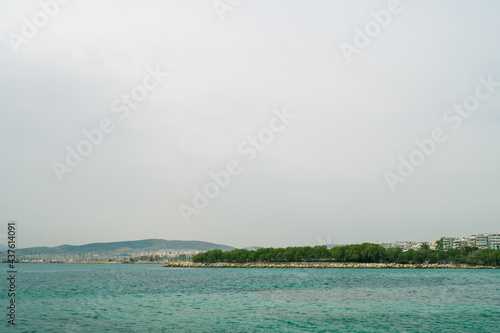 Scenic landscape of Aegean sea and hills. Athens, Greece. Cloudy day. Trees on shore.