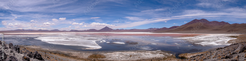 Huge panorama landscape of mountains and blue, red and pink colored lake with reflection and volcanos in natural habitat in atacama desert, uyuni salt flats, chile	