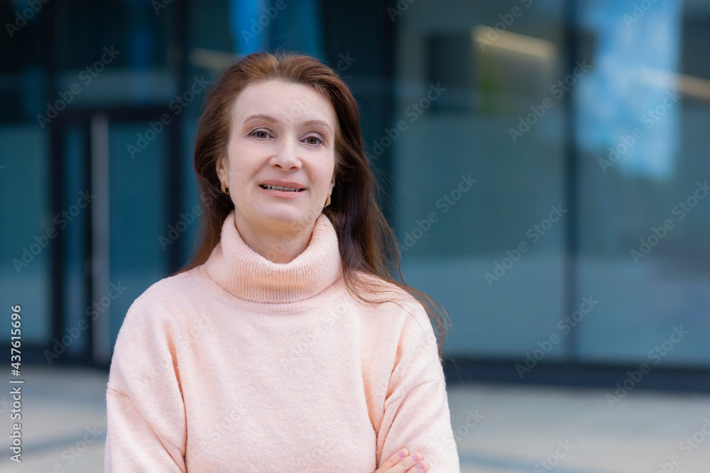 portrait happy kind adult woman, smiling mature middle aged lady with long brunette hair. positive professional attractive female outdoors near building looking at the camera. portrait happy kind adult woman, smiling mature middle aged lady with long brunette hair. positive professional attractive female outdoors near building looking at the camera.