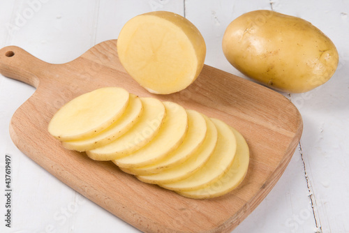 Raw potatoes on wood background