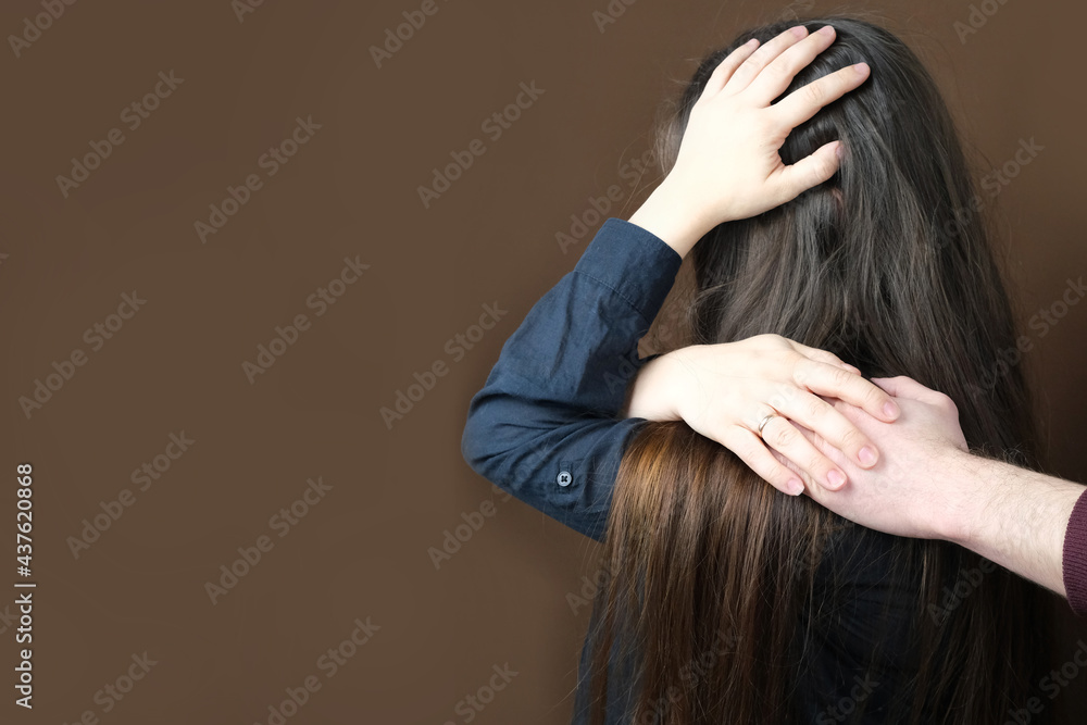 Naklejka premium male hand lies on the shoulder of a crying woman close-up on a dark background, psychological support of a girlfriend, wife in a difficult situation