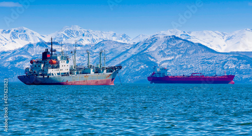 large fishing vessel on the background of hills and volcanoes. Selective focus